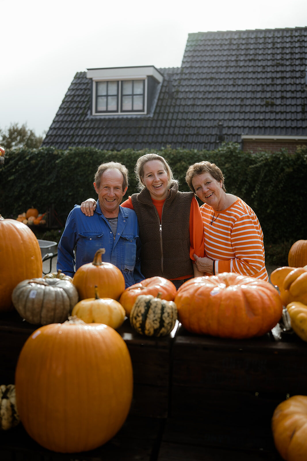 De familie Bos achter een tafel vol pompoenen