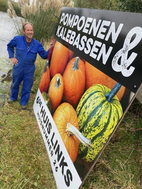 Kees Bos bij het bord van de pompoenenboerderij
